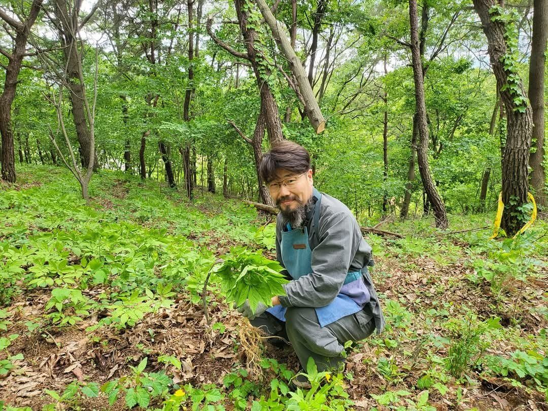 숲에서 산양삼을 든 농부